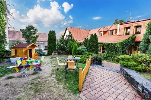 a backyard with a table and chairs and a house at Restaurace a Penzion U Palečků in Skuteč