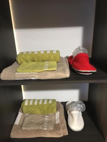 a closet with towels and shoes on a shelf at Au P'tit Bonheur in Cheseaux