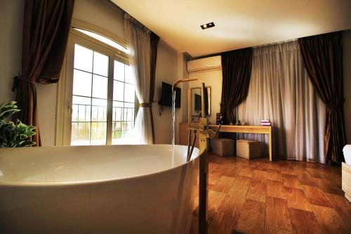 a large bathroom with a tub and a large window at Palm Pyramids View INN in Cairo