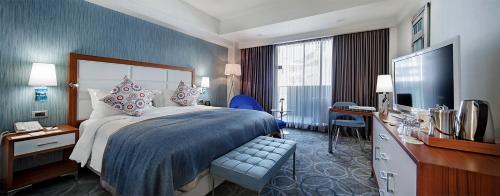 a hotel room with a bed and a television at DoubleTree by Hilton Kusadasi in Kuşadası