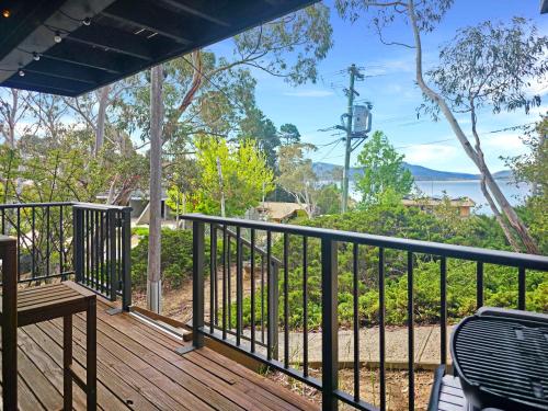 a deck with a bench and a view of the water at The Hideaway - Lake Views I Ski & Bike Storage I Central Jindabyne I Free WiFi I BBQ I Parking in Jindabyne