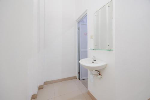 a white bathroom with a sink and a mirror at Urbanview Hotel near Exit Tol BSD in Ciater-hilir