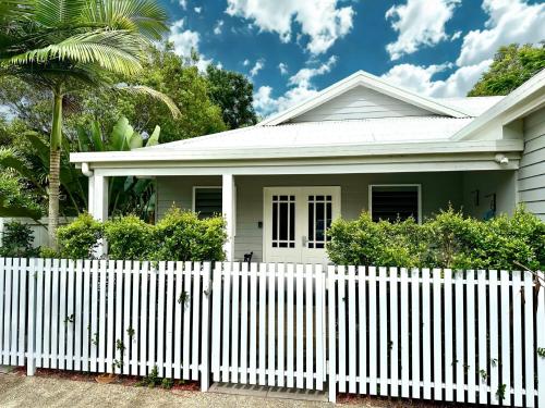 a white picket fence in front of a white house at Bamboo Villa - Edge Hill Cairns Luxury Pet Friendly Sleeps 3 in Edge Hill
