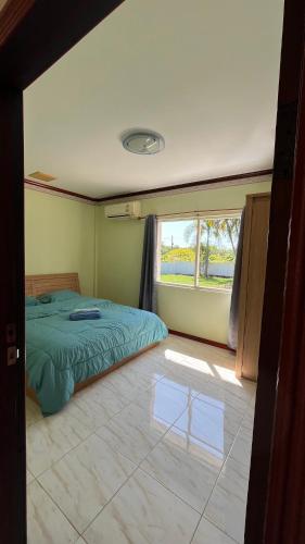 a bedroom with a green bed and a window at Liina House in Ko Yao Noi