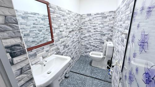 a bathroom with a white sink and a toilet at Sunset Villa in Hambantota
