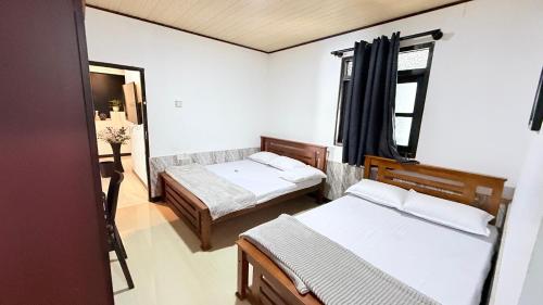 a small room with two beds and a window at Sunset Villa in Hambantota