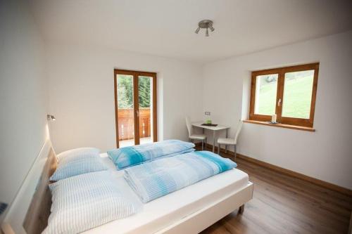 a bedroom with a bed with blue and white pillows at Appartement Bachguter in Avelengo