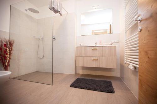 a bathroom with a shower and a sink and a mirror at Appartement Bachguter in Avelengo