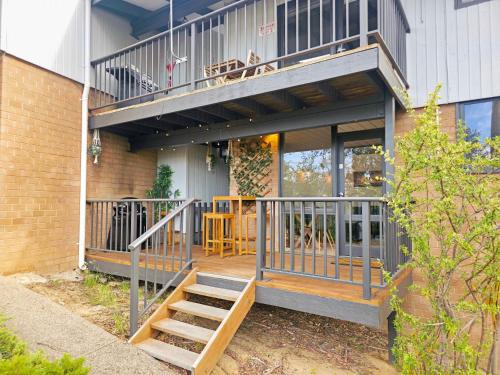 a house with a balcony and a staircase on it at The Hideaway - Lake Views I Ski & Bike Storage I Central Jindabyne I Free WiFi I BBQ I Parking in Jindabyne