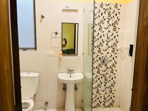 a bathroom with a sink and a toilet and a shower at Paradise Villa in Siliguri