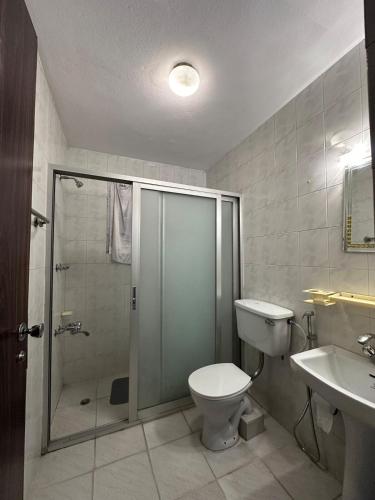 a bathroom with a shower and a toilet and a sink at Manang De cafe B and B in Kathmandu