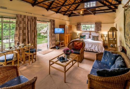 a bedroom with a bed and a table and chairs at Random Harvest Country Cottages in Muldersdrift