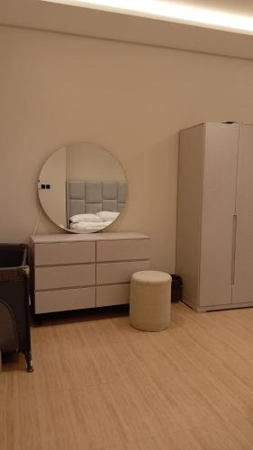 a bedroom with a circular mirror and a bed at كمباوند ماربيلا الكورنيش شقة in Ar Rākah