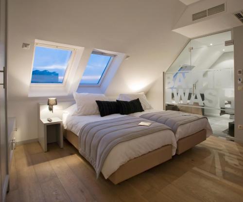 a bedroom with a large bed and two windows at Tuinhotel in Lommel