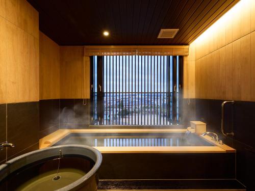 a large bath tub in a room with a window at Rakuten STAY Awara Onsen in Awara