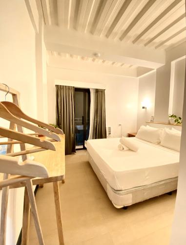a white bedroom with a bed and a chair at Ahava Boutique Hotel in Pooc