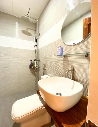 a bathroom with a sink and a toilet and a mirror at Ahava Boutique Hotel in Pooc