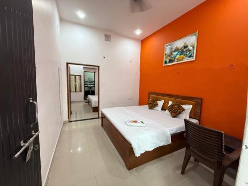 a bedroom with a bed with an orange wall at Shree Balaji home stay Ayodhya contact number 92782-97365 in Ayodhya