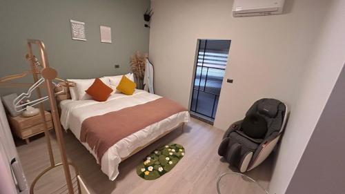 a bedroom with a bed and a chair in it at Wumu B&B in Hengchun South Gate