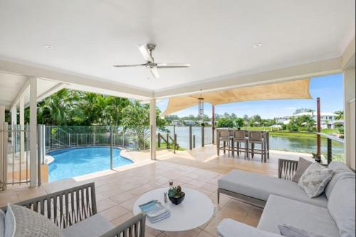 a living room with a couch and a table and a pool at Serene Lakefront Villa, Westlake, Brisbane in Westlake