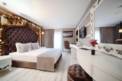 ein Schlafzimmer mit einem großen Bett mit großem Kopfteil in der Unterkunft Demonti Hotel in Ankara