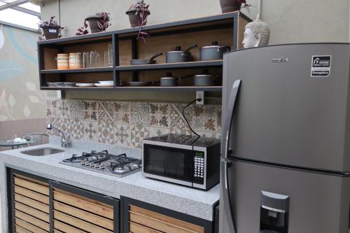 a kitchen with a microwave and a refrigerator at Casa Saratoga in Mexico City