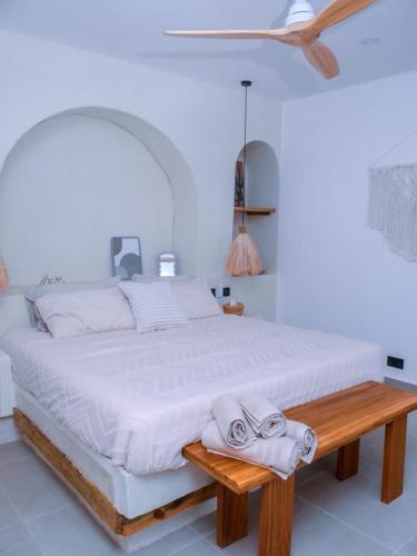 a bedroom with a large bed and a wooden table at Villa Moja in Nungwi