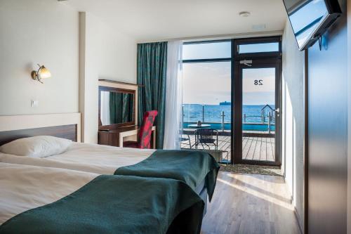 a hotel room with a bed and a view of the ocean at Pirita Beach Apartments & SPA in Tallinn