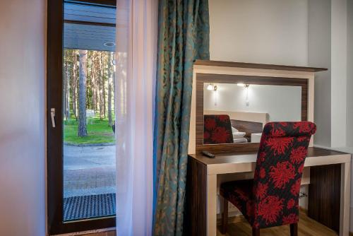 a bedroom with a desk with a chair and a mirror at Pirita Beach Apartments & SPA in Tallinn