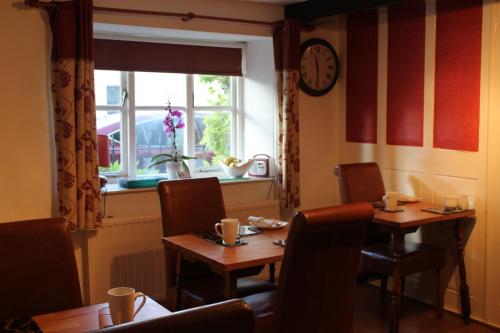 a dining room with two tables and a window at Brewery Farm House Bed & Breakfast in Swindon