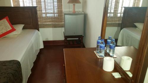 a room with a bed and a table with bottles on it at Ahangama Eco Villa in Ahangama