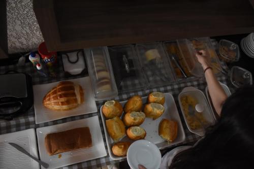 a table with a bunch of bread and pastries at Hotel Holiday Foz in Foz do Iguaçu