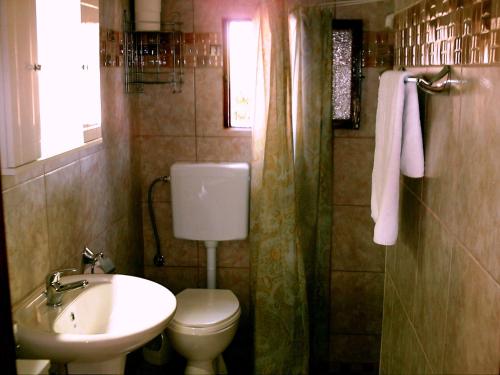 łazienka z toaletą i umywalką w obiekcie Summer Lodge w mieście Maleme