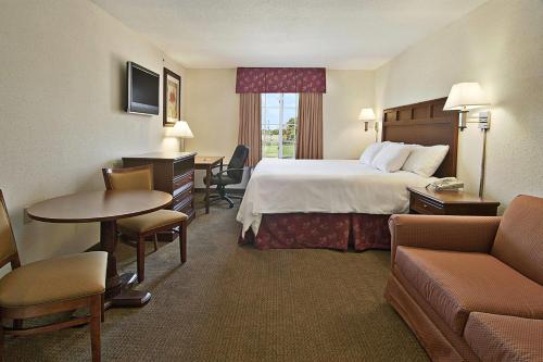a hotel room with a bed and a table and chairs at Super 8 by Wyndham Bowling Green North in Bowling Green
