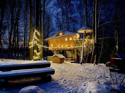 a tree house in the snow with christmas lights at Treehous Sněžník s wellness in Dolní Morava