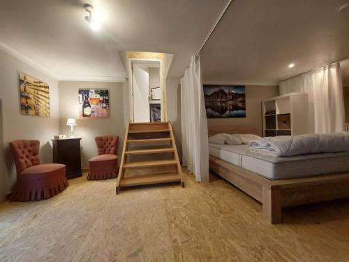 a bedroom with a bed and a staircase in it at L'Ecole in Dinant