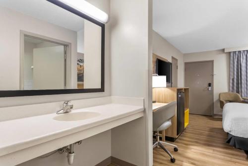 a bathroom with a sink and a mirror at Days Inn by Wyndham Valdosta I-75 in Valdosta