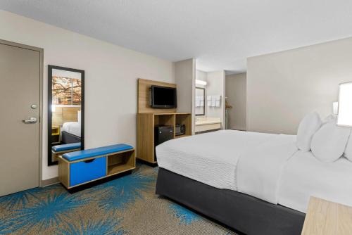 a hotel room with a bed and a television at Days Inn by Wyndham Valdosta I-75 in Valdosta
