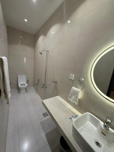 a bathroom with a sink and a toilet and a mirror at Shelton Rezidor House Peshawar in Peshawar