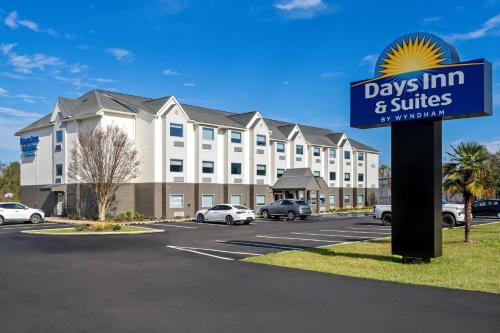 a sign in a parking lot in front of a days inn and suites at Days Inn & Suites by Wyndham Brandon Amphitheater in Brandon
