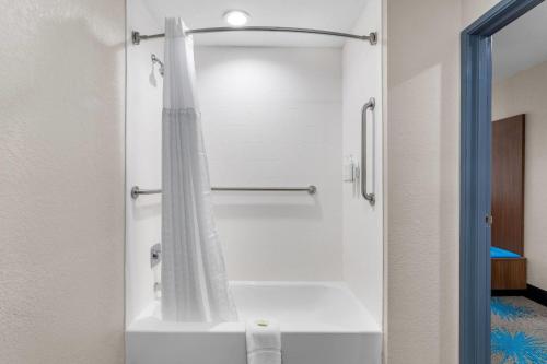 a shower with a white shower curtain in a bathroom at Days Inn & Suites by Wyndham Brandon Amphitheater in Brandon