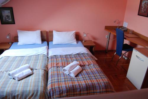 two beds sitting next to each other in a room at Car Royal Apartments and Rooms in Novi Sad