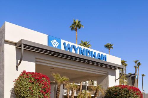 a wynnham sign on a building with palm trees at Wyndham Phoenix Airport - Tempe in Tempe