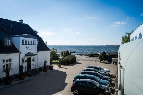 a row of parked cars parked next to a building at Hotel Faaborg Fjord in Faaborg