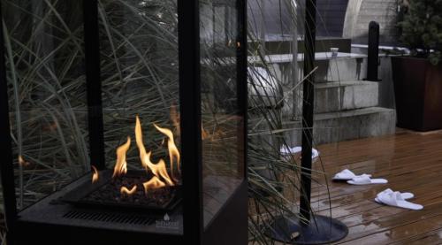 a fire pit in a living room with someones shoes at Hotel Faaborg Fjord in Faaborg