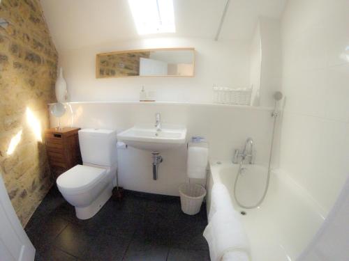 a bathroom with a toilet and a sink and a shower at Scotney Place in Stamford