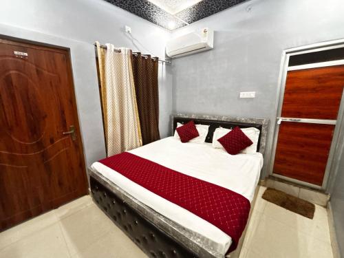 a small bedroom with a bed with red pillows at Hotel O Suryavanshi Palace in Ayodhya