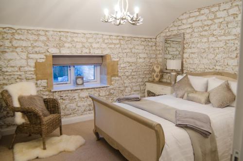 a bedroom with a bed and a chair and a window at Scotney Place in Stamford