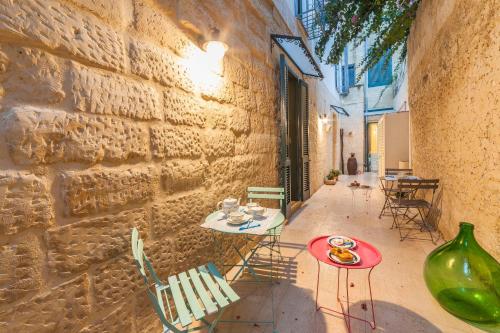 a patio with a table and chairs next to a brick wall at La Luna In Cortile in Lecce