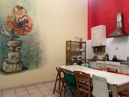 a kitchen with a table and a painting on the wall at 6 Small rooms in Naples